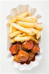 Currywurst (sausage with ketchup & curry powder) & chips in paper dish