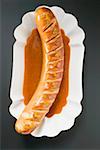 Currywurst (Bratwurst mit Ketchup & Currypulver) in Papier-Schale