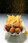 Saupoudrer de poudre de curry sur currywurst et chips