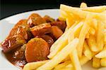 Currywurst (saucisse avec ketchup & cari) & des chips sur plaque