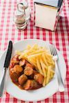 Currywurst (sausage with ketchup & curry powder) & chips in restaurant