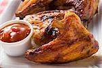 Grilled chicken wings with ketchup (close-up)