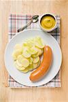 Frankfurter with potato salad, mustard in small dish