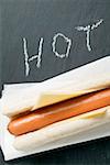 Hot dog au fromage sur la serviette en papier, le mot « Chaude »