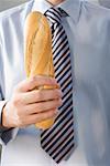Man in tie holding baguette