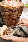 Making a döner kebab: filling pita bread with meat