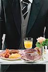 Butler serving English breakfast on tray