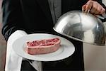 Butler rohen Beefsteak auf Platte serviert, mit Domdeckel