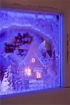 View of a gingerbread house through a blue window