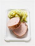 Leberk0se (type of meatloaf) with potato salad on paper plate