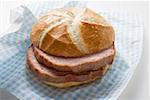 Slices of Leberk0se (type of meatloaf) in a roll on paper napkin