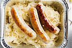 Sausages with sauerkraut in aluminium container to take away