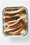 Würstchen mit Sauerkraut in Aluminiumbehälter zum Mitnehmen