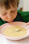 Small boy eating noodle soup