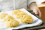 Person, die hausgemachte Pasta auf Weide-Tablett