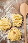 Home-made ribbon pasta beside wooden spoon