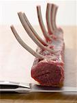 Rack of lamb on chopping board with knife