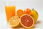 Glass of fruit juice and fresh citrus fruit