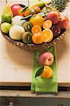 Eine Auswahl an frischem Obst in einem Korb auf einem Holztisch