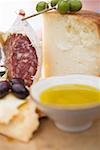 Olives, crackers, olive oil, Parmesan and salami