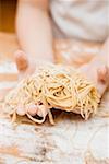 Child's hands holding home-made linguine