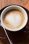 Espresso with milk froth in shape of heart (overhead view)