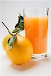 Glass of orange juice and two oranges