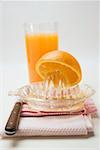 Presser un orange, verre de jus d'orange