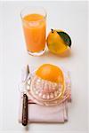 Presser une orange, verre de jus d'orange & orange complet