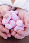 Child's hands holding pink sugared almonds