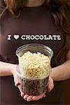 Woman holding two plastic tubs of chocolate chips