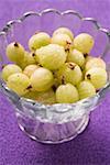 Gooseberries with drops of water in glass