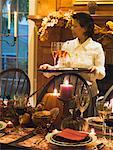 Table laid for Thanksgiving, woman serving sparkling wine (USA)