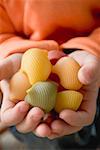 Child's hands holding coloured lumaconi