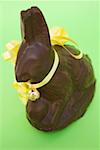 Lapin de Pâques au chocolat avec un arc jaune et petite cloche