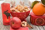 Christmas decoration: nuts, orange, apple, cinnamon, candle