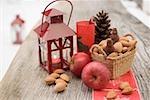 Christmas decoration with apples, nuts & lantern on table