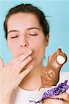 Woman holding chocolate Easter Bunny with a bite taken