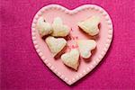 Heart-shaped jam-filled biscuits on pink plate