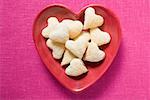 Heart-shaped jam-filled biscuits in red dish