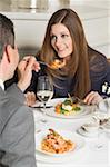 Homme offrant femme crevettes sur la fourche en restaurant