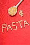 The word 'Pasta' written in pasta pasta on wooden spoon