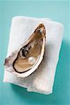 Fresh oyster with pearl on towel