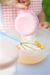 Child adding flour to egg yolks