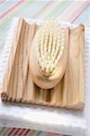 Wooden soap dish with brush on white towel