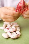 Mains de l'enfant avec haricots borlotti et pod