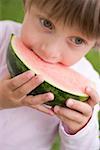 Kind in Wassermelone beißen