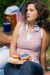 Jeune femme tenant la plaque de beignets sur la 4th of July (USA)