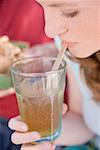 Young woman drinking iced tea through a straw