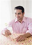 Young man holding a glass of lemon juice and smiling